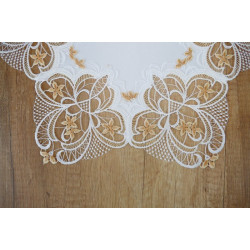 Nahaufnahme von feiner Plauener Spitze in Weiß und Beige mit floraler Stickerei als edler Tischläufer.