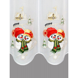 Detailaufnahme der bestickten Weihnachtsgardine mit Schneemann-Paar, Tannen und Haus auf weißem Stoff.
