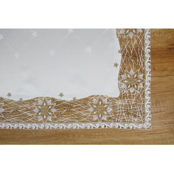 Nahaufnahme von feiner Plauener Spitze mit eingewebten Goldfäden und Sternenmotiven auf cremefarbenem Textil.