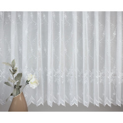 Detailansicht weißer Store mit filigranen Blumenranken aus echter Plauener Spitze für stilvolle Fensterdekoration.