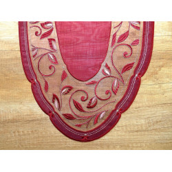 Detail eines bordeauxroten Tischläufers aus Plauener Spitze mit eleganten Stickereien und Lurex-Glanzfäden.