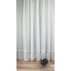 Halbtransparente Gardine mit moderner Plauener Spitze im Wohnbereich, hängend über hellem Laminatboden.