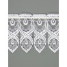 Nahaufnahme weißer Plauener Spitze: Filigrane Scheibengardine mit geschwungenem Ornament-Muster.