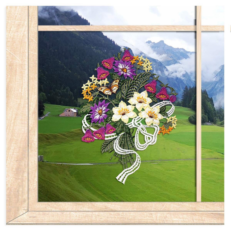 Plauener Spitze Fensterbild mit buntem, filigran gesticktem Frühlingsstrauß am Fenster vor einer grünen Wiese.