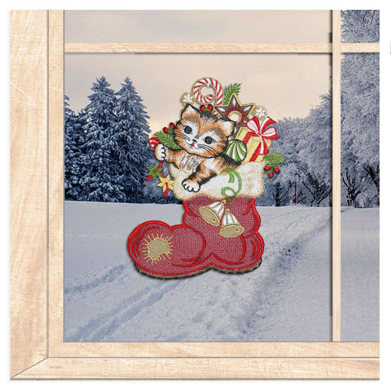Gesticktes Fensterbild mit niedlicher Katze im roten Weihnachtsstiefel vor winterlich verschneitem Wald-Ambiente.