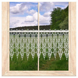 Transparente Scheibengardine aus weißer Plauener Spitze am Holzfenster mit Blick auf grüne Landschaft.