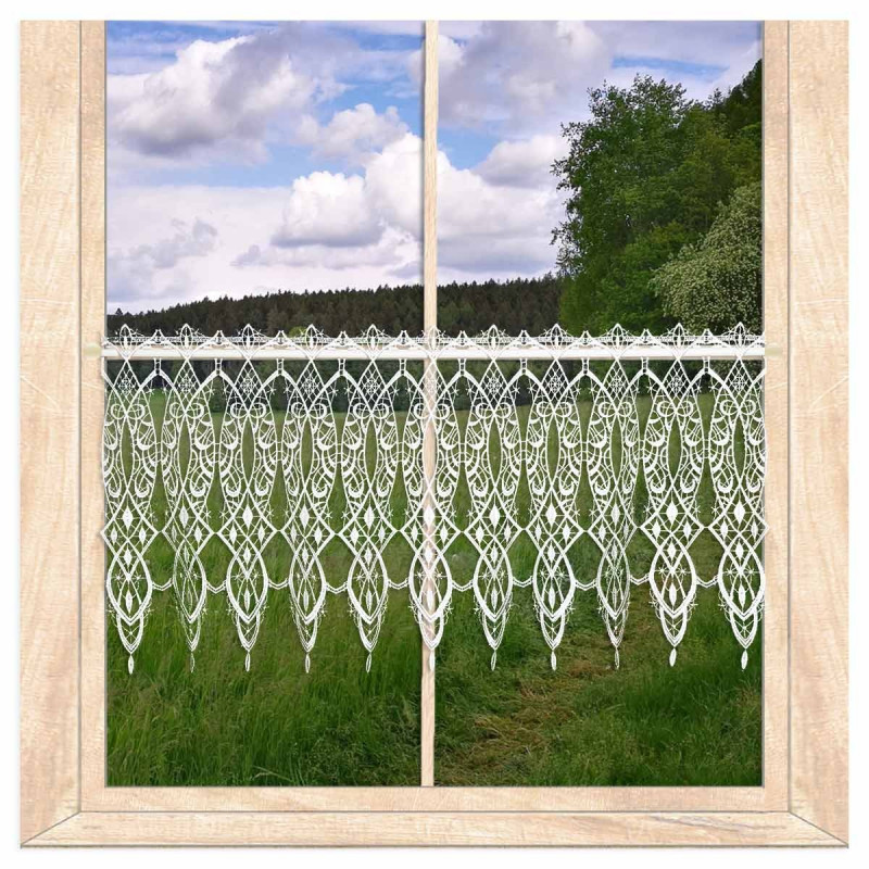 Transparente Scheibengardine aus weißer Plauener Spitze am Holzfenster mit Blick auf grüne Landschaft.