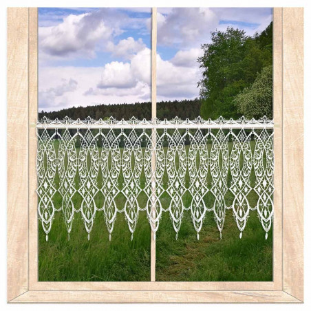 Transparente Scheibengardine aus weißer Plauener Spitze am Holzfenster mit Blick auf grüne Landschaft.