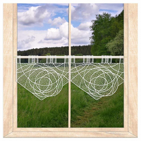 Am Fenster dekoriert: Transparente Kurzgardine Suna aus weißer Plauener Spitze mit Ausblick ins Grüne.