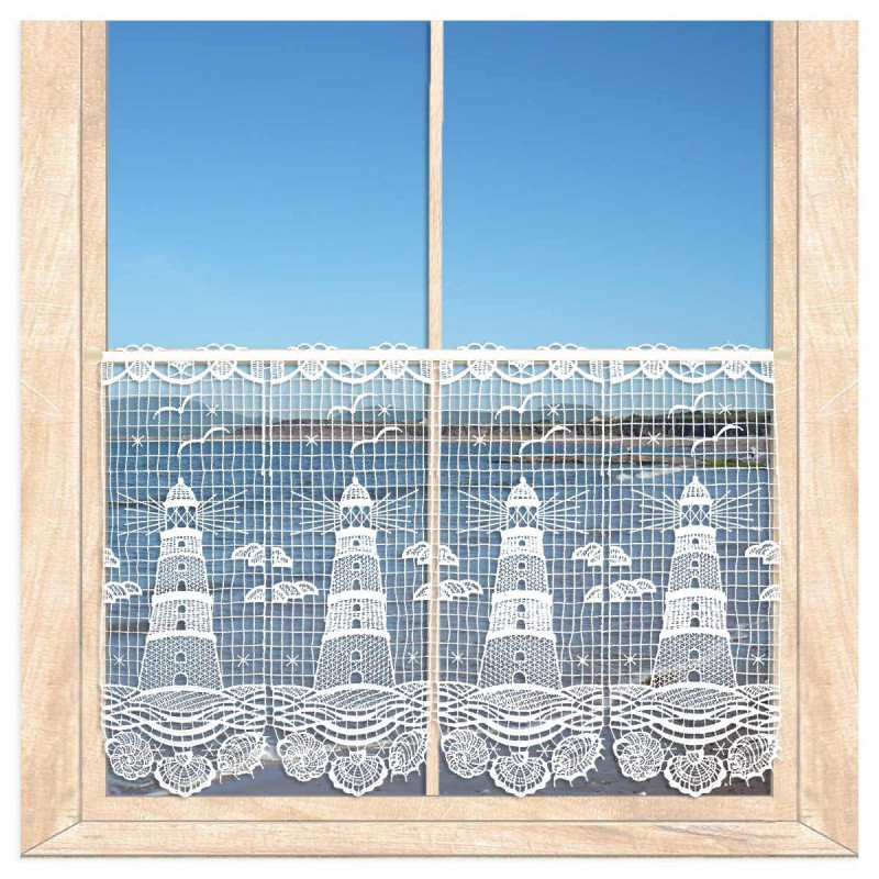 Am Fenster dekoriert: Transparente Kurzgardine Leuchtturm aus weißer Plauener Spitze vor blauem Himmel und Meer.