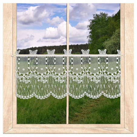 Transparente Bistrogardine aus weißer Plauener Spitze mit Schmetterlingsmotiv am Fenster vor Wiesenlandschaft.