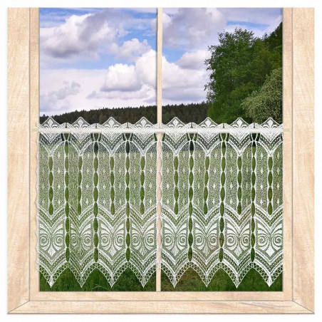 Naturweiße Kurzgardine aus Plauener Spitze am Holzfenster vor Wiesenlandschaft für ein gemütliches Zuhause.