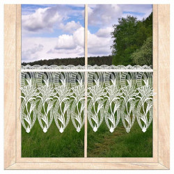 Weiße Kurzgardine aus Plauener Spitze mit floralem Lilienmuster am Holzfenster vor grüner Landschaft. 33 cm hoch