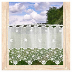 Halbtransparente Bistrogardine aus naturweißer Plauener Spitze mit Blütenmotiv am Fenster vor grüner Natur.