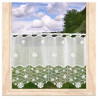 Halbtransparente Bistrogardine aus naturweißer Plauener Spitze mit Blütenmotiv am Fenster vor grüner Natur.
