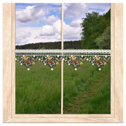 Kleine Spitzengardine mit detailreichen, bunt gestickten Schmetterlingen am hellen Fenster.