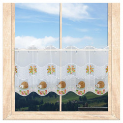 Weiße Vitrage mit Igel- und Herbstlaub-Stickerei als herbstliche Fensterdekoration im Zimmer mit Blick ins Grüne. 35 cm hoch