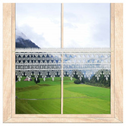 Plauener Spitze Scheibengardine als eleganter Sichtschutz im Fenster vor Bergpanorama. 27 cm hoch