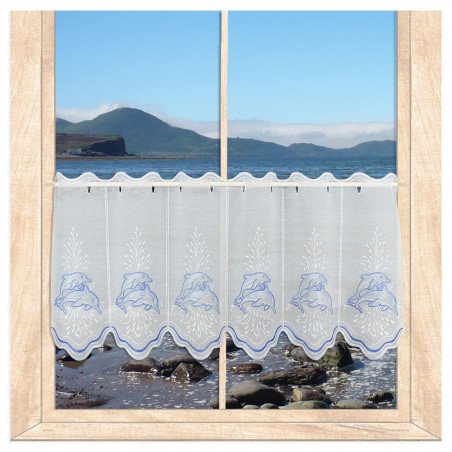 Blau-weiße Stickerei-Scheibengardine mit Delfin-Stickerei am sonnigen Fenster. 40 cm hoch