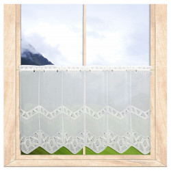 Modern bestickter Kurzstore Dana  55 cm hoch an einem hellen Holzfenster.