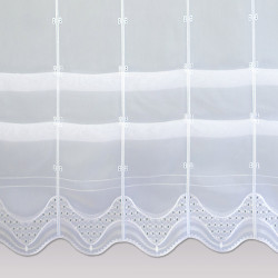 Detail einer weißen Plauener Spitze Raffgardine mit bogenförmigem Abschluss und Lochstickerei-Mustern.