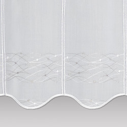 Nahaufnahme von weissem Voile mit feiner floraler Wellen-Stickerei und Ziersaum.