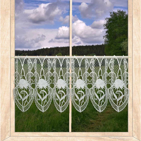 Transparente Kurzgardine aus naturweißer Plauener Spitze mit Pfingstrosenmotiv am Fenster mit Ausblick ins Grüne.