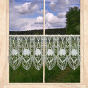 Transparente Kurzgardine aus naturweißer Plauener Spitze mit Pfingstrosenmotiv am Fenster mit Ausblick ins Grüne.