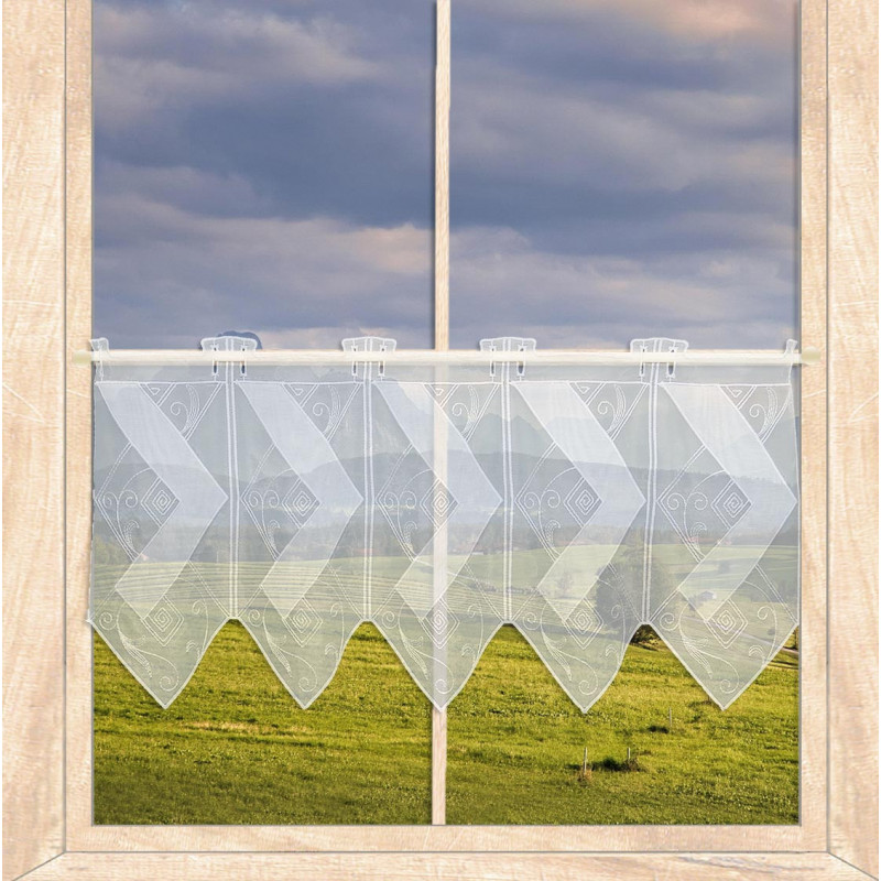 Weiße Kurzgardine mit Rauten-Muster, dekoriert am Fenster mit Blick auf eine grüne Wiesenlandschaft.