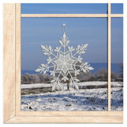 Kristalline Schneeflocke aus weißer Plauener Spitze als winterliche Fensterdekoration am Fenster.