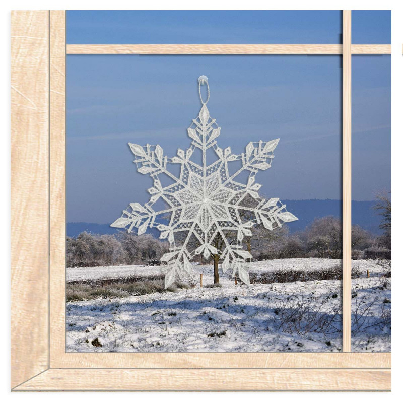 Kristalline Schneeflocke aus weißer Plauener Spitze als winterliche Fensterdekoration am Fenster.
