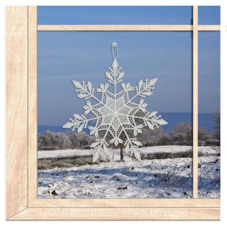 Kristalline Schneeflocke aus weißer Plauener Spitze als winterliche Fensterdekoration am Fenster.