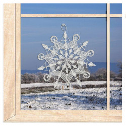 Verzierte Schneeflocke aus weißer Plauener Spitze als romantisches Fensterbild im winterlichen Ambiente.