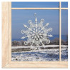 Verzierte Schneeflocke aus weißer Plauener Spitze als romantisches Fensterbild im winterlichen Ambiente.