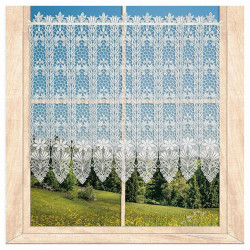 Naturweiße Kurzgardine aus Plauener Spitze mit Blumenmuster am Holzfenster vor grüner Landschaft.