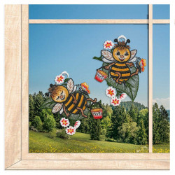 Zwei niedliche Bienen-Fensterbilder aus Plauener Spitze als farbenfrohe Sommer-Deko vor Landschaft.