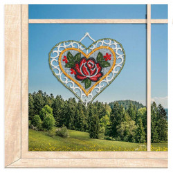 Am Fenster dekoriert: Plauener Spitze Fensterbild Herz mit roter Rose vor naturnaher Kulisse als Heimtextil.