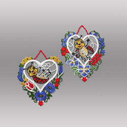 Freigestellte Plauener Spitze Fensterbilder als Herzen mit bunten Blumen und niedlichen Käfer-Motiven vor grauem Grund.