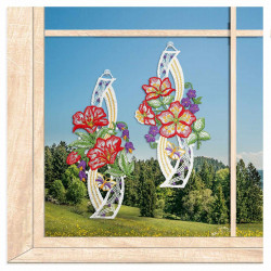 Florale Spitze-Fensterbilder mit Hibiskus- und Kirschblüten vor einem Fenster mit weitem Ausblick auf Berge und Wiesen.