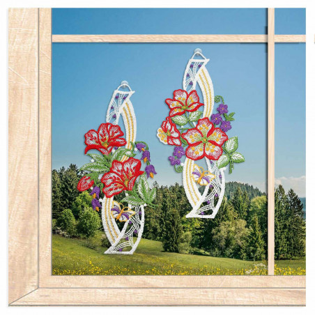 Florale Spitze-Fensterbilder mit Hibiskus- und Kirschblüten vor einem Fenster mit weitem Ausblick auf Berge und Wiesen.