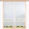 Clipstore mit filigranem Ranken-Muster an einem Holzfenster mit Blick auf eine sommerliche Wiese.