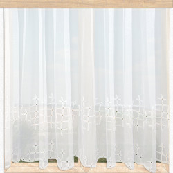 Nahaufnahme der weißen Scheibengardine Mia am Fenster. Luftige Textur mit modernem Stickerei-Muster.