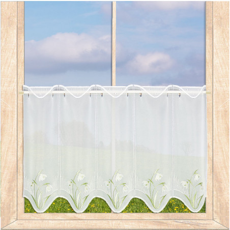 Halbtransparente weiße Scheibengardine mit Schneeglöckchen-Stickerei am Fenster mit Frühlingsausblick.