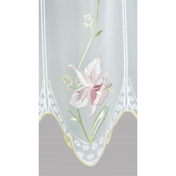Nahaufnahme der filigran gestickten Orchidee in Rosa auf feiner weißer Scheibengardine aus Plauener Spitze.