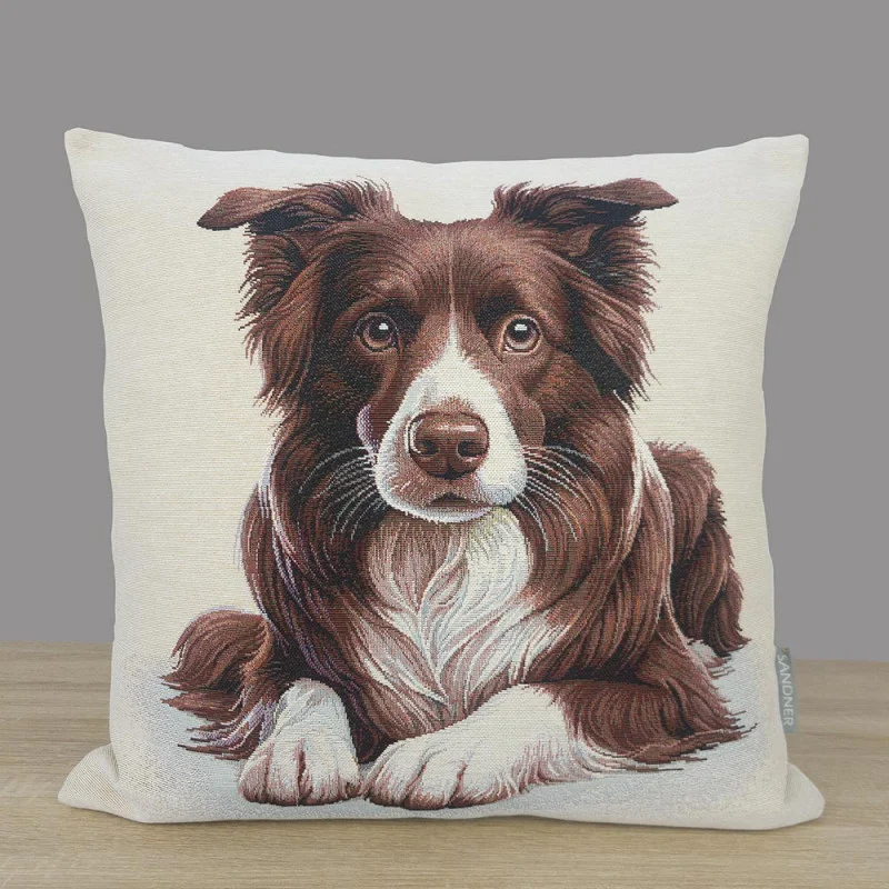 Das Bild zeigt einen quadratischen Kissenbezug aus hochwertigem Gobelin-Gewebe. Im Zentrum des Motivs steht das detailliert gewebte Porträt eines Border Collies in den Farben Braun und Weiß. Der Hund ist in einer liegenden Position dargestellt, wobei der Blick treu und aufmerksam direkt nach vorne gerichtet ist.