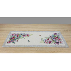 Der Gobelin-Tischläufer verfügt über einen cremefarbenen Grund mit einem markanten, grau melierten Randabschluss. Die Anordnung der Blumen sind in üppigen Eckmotiven zu sehen.