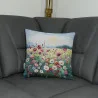 Das Kissen Flora auf einem grauen Sofa platziert.