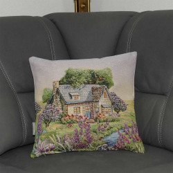 Ein kleines englisches Landhaus in einer üppig blühenden Landschaft mit einem Bach zeigt sich auf dieser verträumten Kissenhülle auf einem grauen Sofa.