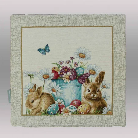 Am unteren Rand dieser Kissenhülle sind liebevoll verzierte Ostereier in verschiedenen Farben (Blau, Rot, Gelb) im grünen Gras versteckt.

Belebte Natur: Zwei Schmetterlinge – einer in leuchtendem Blau und einer in gedecktem Violett – verleihen der Szenerie zusätzliche Dynamik.