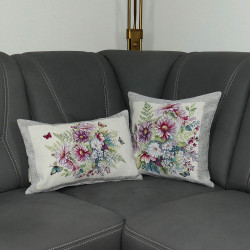 Hier sind beide Kissen der Serie Schmuckkörbchen auf einem grauen Sofa arrangiert.